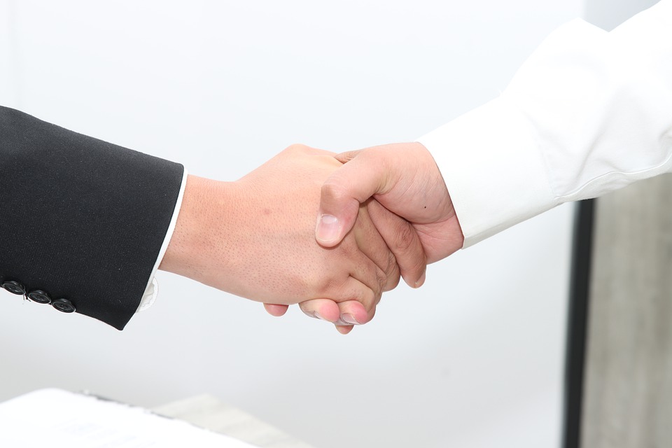 two people shaking hands at a merger and acquisition meeting. business consulting 6